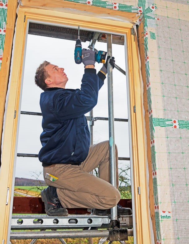 Schreiner montiert ein neues Fenster